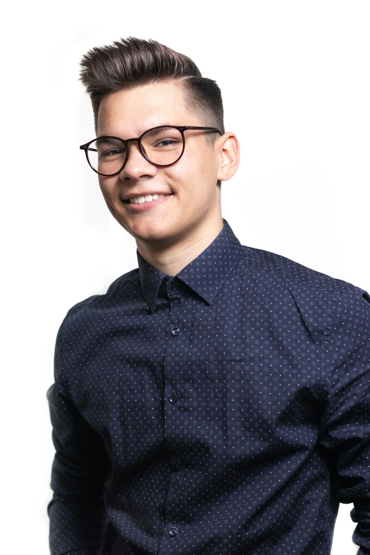 Homem de óculos vestindo camisa azul-marinho com poá