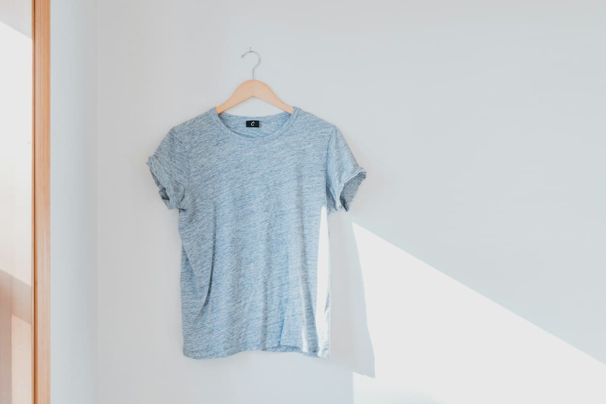 Camiseta cinza mescla pendurada em cabide